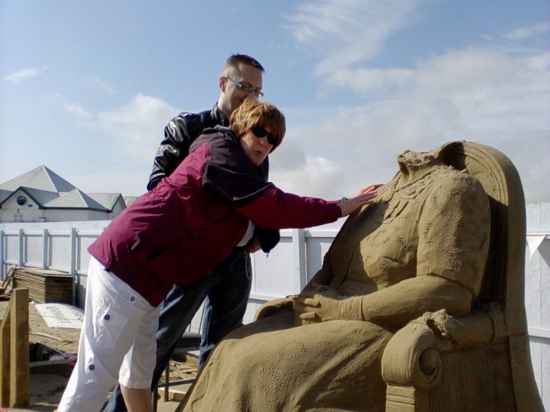 Nick enabling Jean to touch the Queen Elizabeth  sculpture after the vandalism